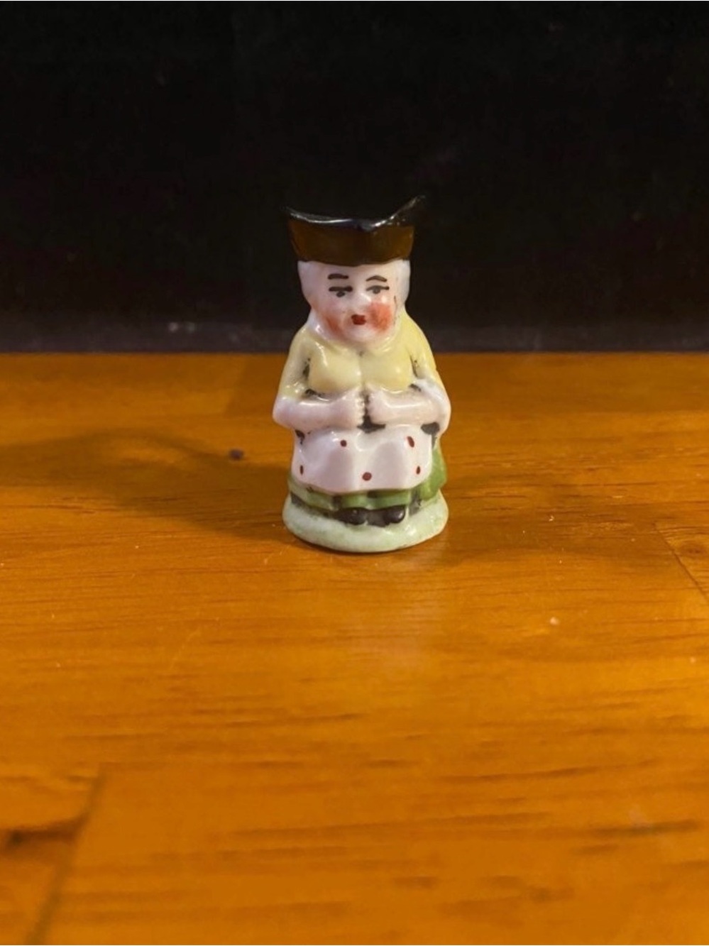 Miniature ceramic colonial grandmother with handle.